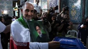 a man casts his ballot during the presidential election as he holds a picture of the late president ebrahim raisi in a polling station in tehran iran friday june 28 2024