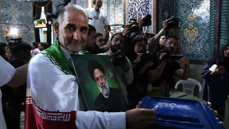 a man casts his ballot during the presidential election as he holds a picture of the late president ebrahim raisi in a polling station in tehran iran friday june 28 2024