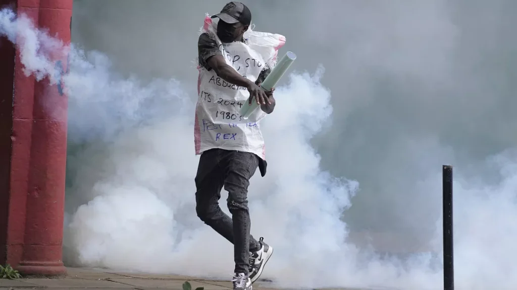 a protester returns back a teargas canister to kenya police in nairobi kenya thursday june 27 2024