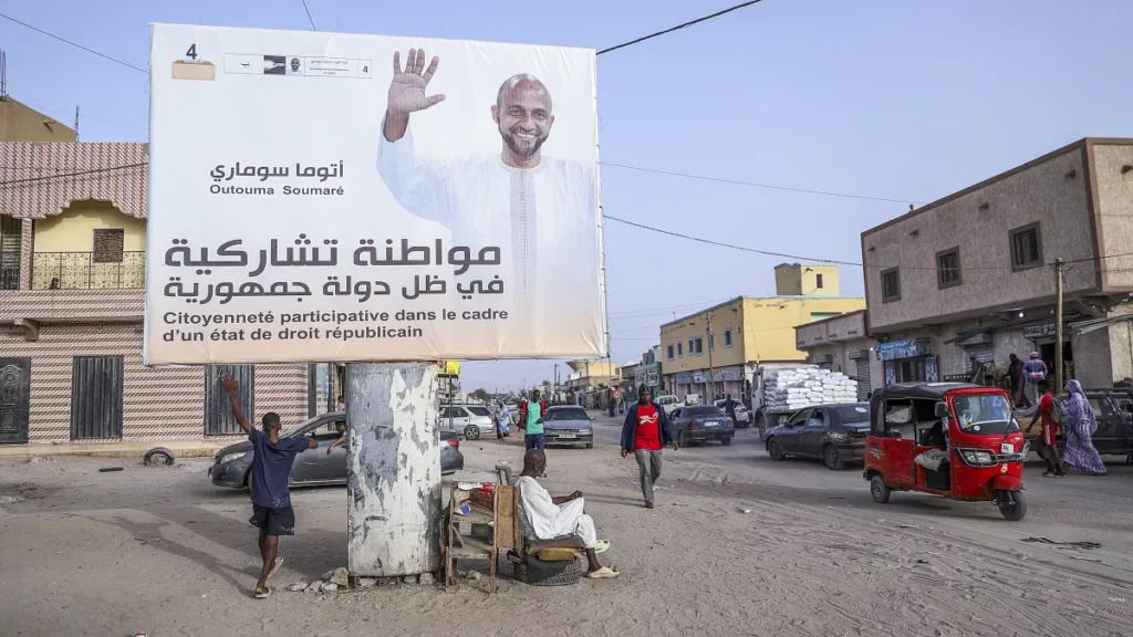 people rest under an electoral banner for presidential candidate outouma soumare ahead of the presidential candidate in nouakchott mauritania on june 25 2024