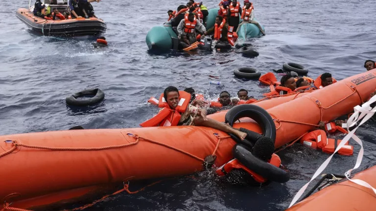 Migrants aboard a rubber boat end up in the water while others cling on to a centifloat