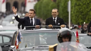 Morocco's king Mohammed VI, right, and French president Emmanuel Macron wave to crowds during the latter's official visit to Morocco
