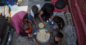 Desperate Palestinians queue for food at soup kitchen during Eid al-Adha