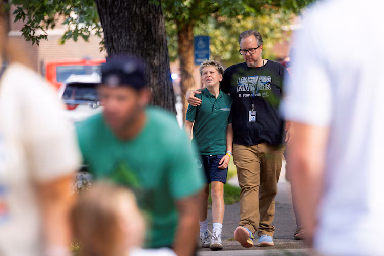 Families and loved ones walk outside the police barricades after a shooting at Annunciation Church, which is also home to a an elementary school, in Minneapolis, Minnesota, August 27, 2025.