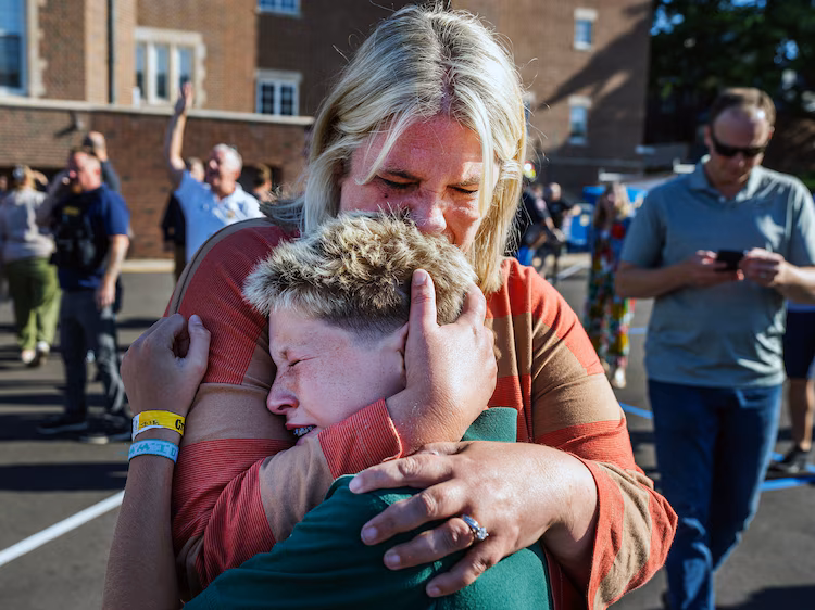 A parent hugs her son during an active shooter situation at the Annunciation Church in Minneapolis, Minn., Aug. 27, 2025.