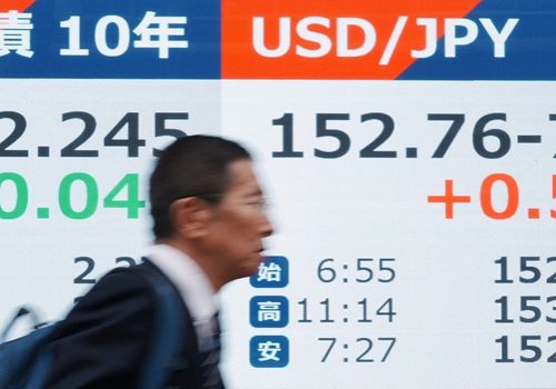 A man walks past an electronic quotation board displaying the foreign exchange rate of Japanese yen against the US dollar (R) and the rate of 10-year government bonds (L) along the sidewalk in downtown Tokyo on January 28, 2026. (Photo by Kazuhiro NOGI / AFP)
