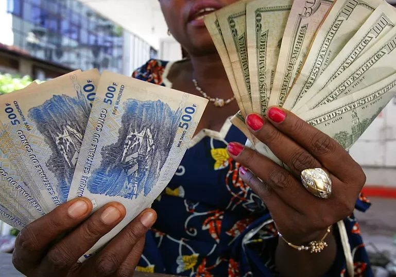 A currency trader displays US dollars and Congolese francs at a local market in Kinshasa Congo Thursday November 9 2006 AP A currency trader displays US dollars and Congolese francs at a local market in Kinshasa Congo Thursday November 9 2006 AP