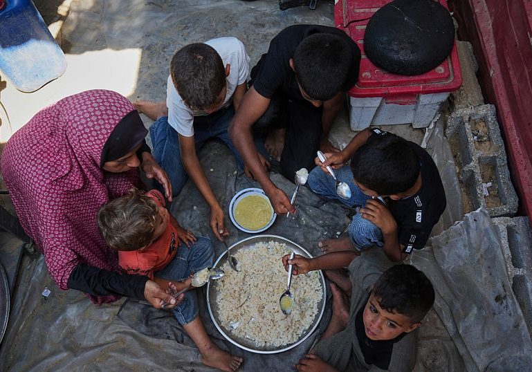 Desperate Palestinians queue for food at soup kitchen during Eid al-Adha