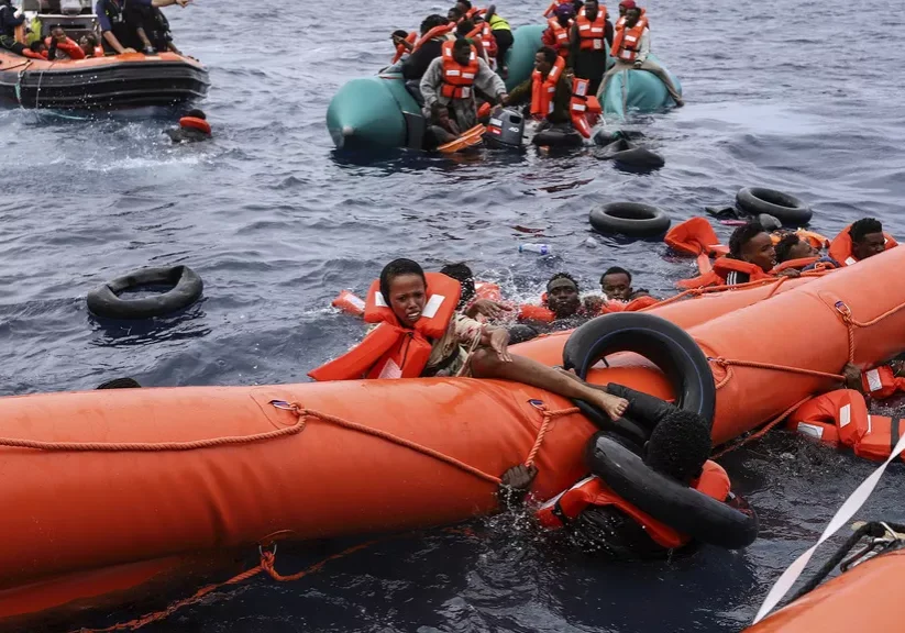 Migrants aboard a rubber boat end up in the water while others cling on to a centifloat Migrants aboard a rubber boat end up in the water while others cling on to a centifloat