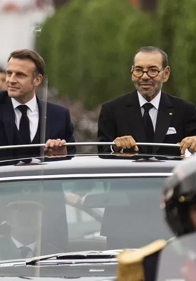 Morocco's king Mohammed VI, right, and French president Emmanuel Macron wave to crowds during the latter's official visit to Morocco