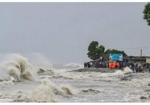 People gather along the sea shore amid rainfall in Kuakata on May 26 2024 ahead of cyclone Remals