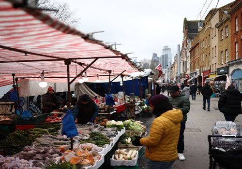 People look at fruit and vegetables displayed for sale on a market stall on Whitechapel High Street in east London on February 12, 2026. (Photo by HENRY NICHOLLS / AFP)