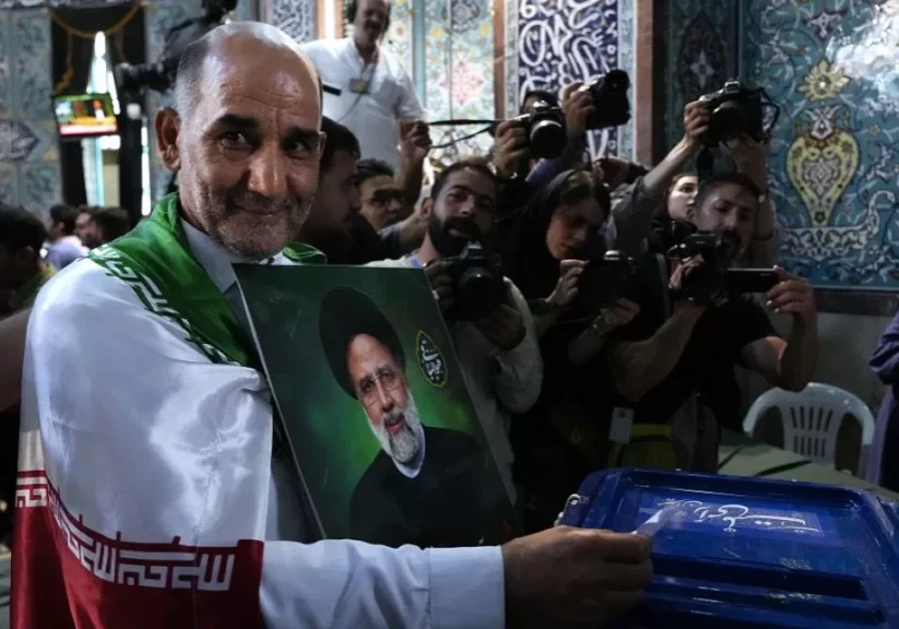 a man casts his ballot during the presidential election as he holds a picture of the late president ebrahim raisi in a polling station in tehran iran friday june 28 2024 a man casts his ballot during the presidential election as he holds a picture of the late president ebrahim raisi in a polling station in tehran iran friday june 28 2024