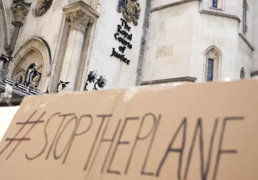 A placard left outside the High Court where the ruling on Rwanda deportation flights is taking place, in London Monday, June 13, 2022 A placard left outside the High Court where the ruling on Rwanda deportation flights is taking place, in London Monday, June 13, 2022