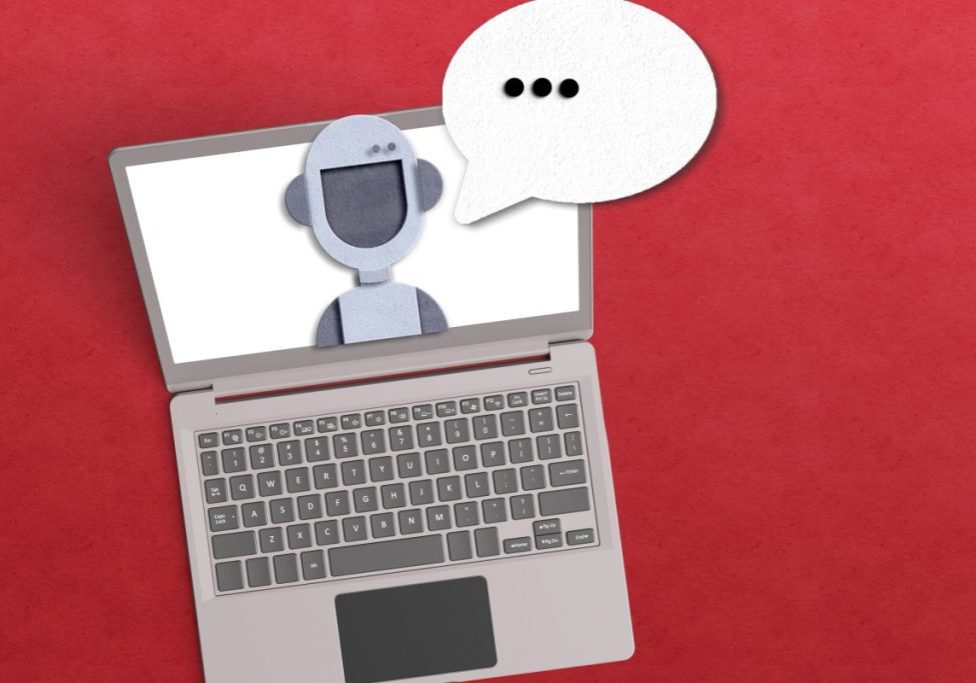 AI agent concept with robot inside a laptop with a voice bubble on red background.