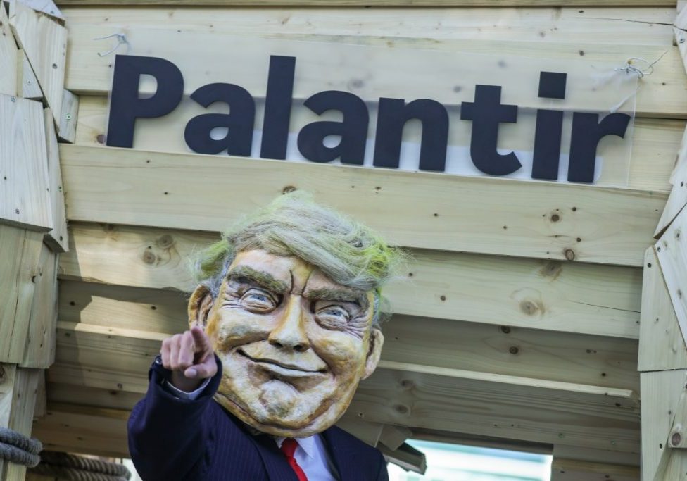 An activist dressed as U.S. President Donald Trump stands in front of a mock Trojan horse